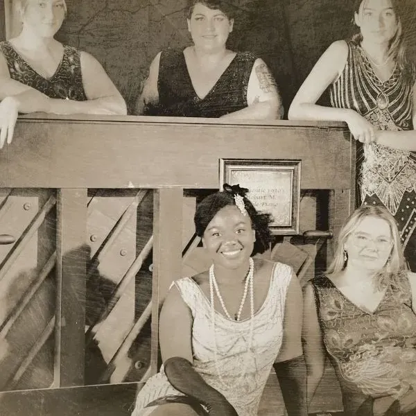 an old style photo with women sitting in front of a desk